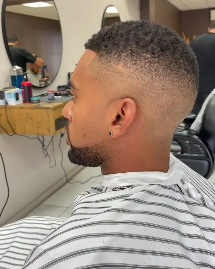 Finished fade and beard shape from the side in a barber chair