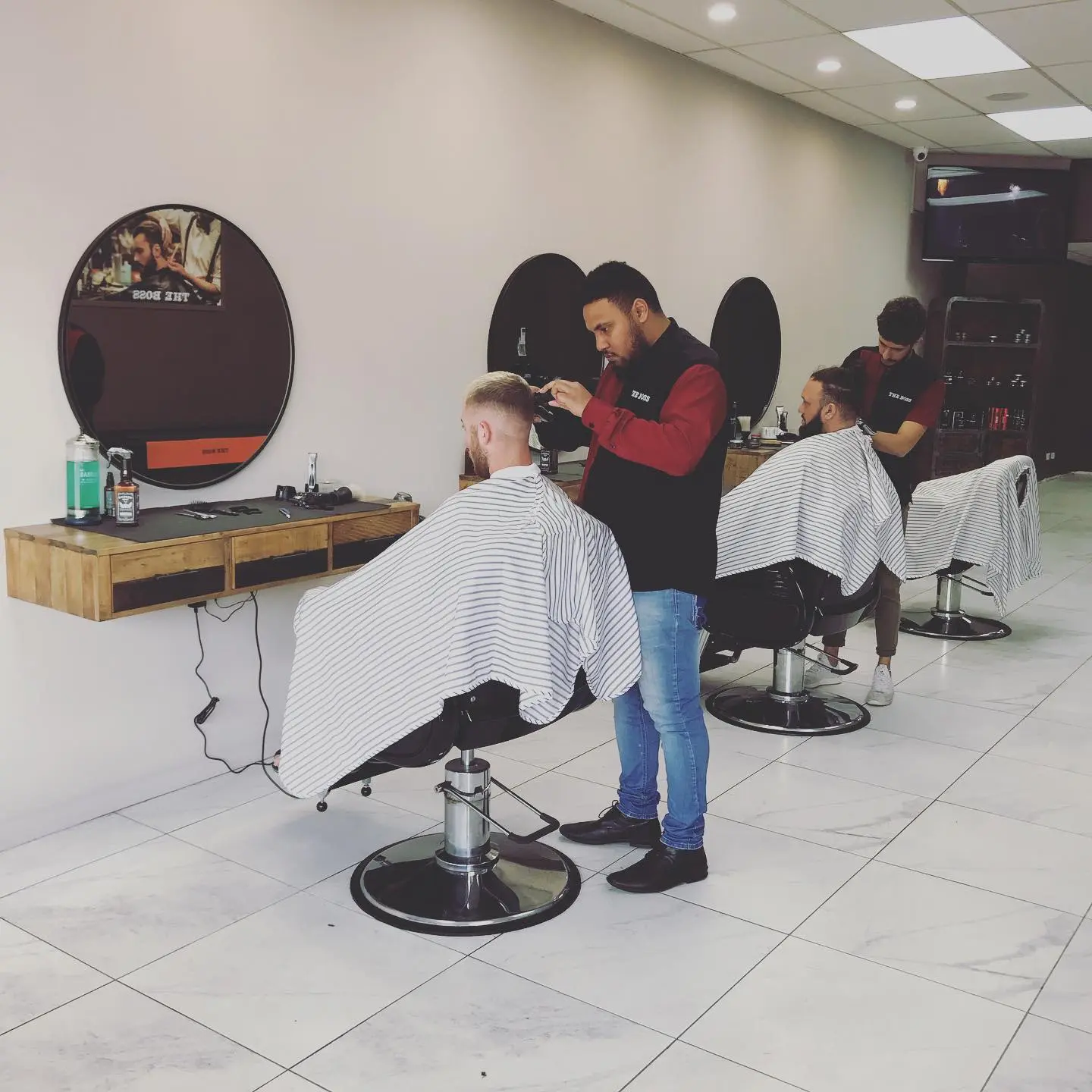 Barbers working with clients inside The Boss grooming lounge